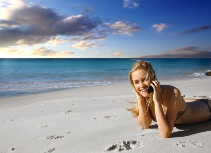 Woman using phone on a beach